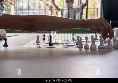 A girl makes her move in a game of chess against a boy in her classroom Stock Photo