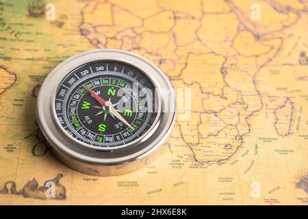 Bangkok, Thailand - January 20, 2022 Compass for navigation on vintage old antique world map background to travel, geography, tourism and exploration Stock Photo
