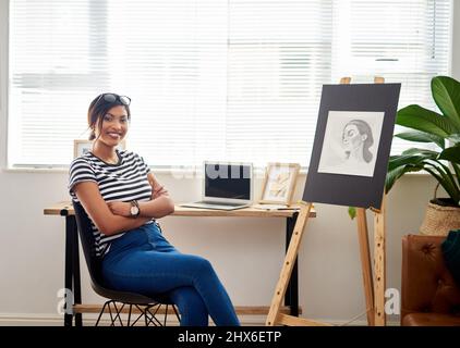 Let the world stare in amazement of your creativity. Portrait of an attractive young artist smiling and feeling cheerful while sitting inside her Stock Photo