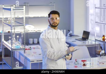 Portrait of serious researcher conducting scientific research in modern medical laboratory. Stock Photo