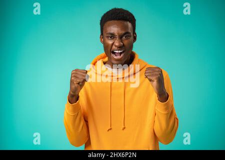 Portrait of overjoyed black man celebrating success in studio Stock Photo