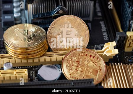Golden bitcoins on a computer  main board . Crypto currency coins on  mother board background. Stock Photo