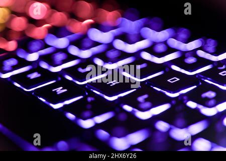 Neon computer keyboard with color backlight. Computer video games, hacking, technology, internet concept. Selected focus. High quality photo Stock Photo