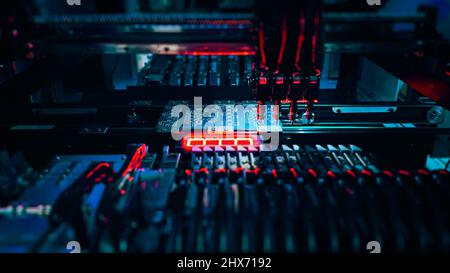 Automatic production Computer Chips by SMT Pick and Place machine. Robot Manipulators for assembling computer chips and system computer boards place electronic components on board for fixing. Stock Photo