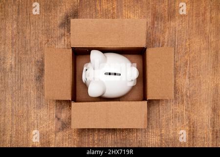 Ceramic piggy bank in open box made from corrugated cardboard Stock Photo