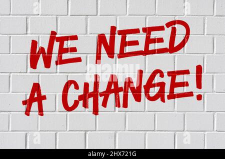 Graffiti on a brick wall - We need a change Stock Photo