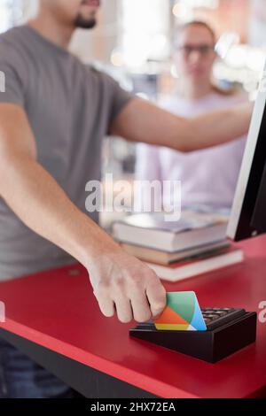 Student borrowing books with library card Stock Photo
