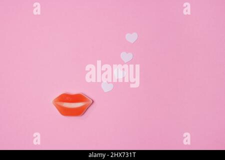 Red lips and paper hearts on pink background Stock Photo
