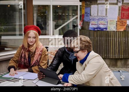 Young friends sitting together Stock Photo