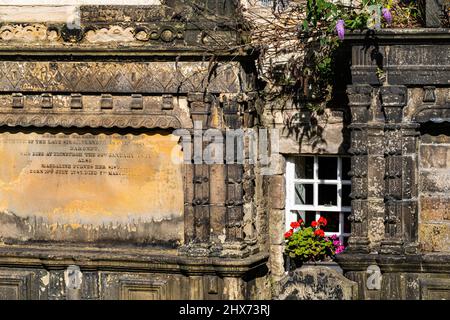 Detail of Victorian Headstones Set Against the Wall of Houses Facing Candlemaker Row, a Window With Bright Window Box and Plant Colonisation Stock Photo