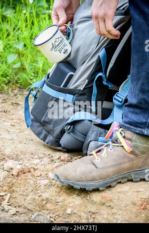 coffee mug hanging on hikers backpack Stock Photo