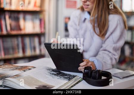 Female student using digital tablet in library Stock Photo