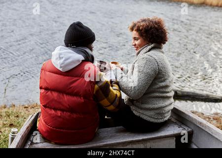 Friends sitting on old boat and talking Stock Photo