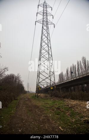 Electricity pylon next to a path in a park in autumn Stock Photo - Alamy