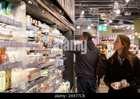 Shoppers take food items from a shelf in Whole Foods supermarket.   Food prices, among other living costs, are said to spike in months coming up follo Stock Photo