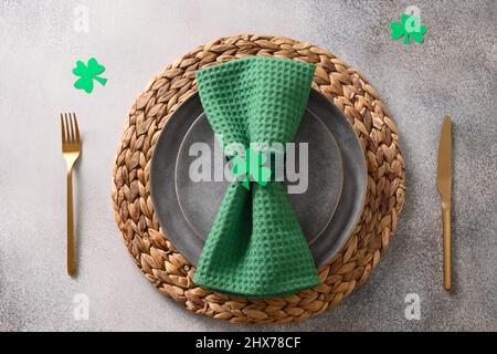 St Patrick's Day table setting with green decor on gray background. View from above. Copy space. Stock Photo
