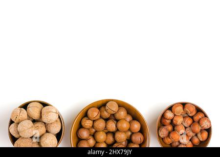 natural organic macadamia, walnut, hazelnut nuts in wooden bowl on white background Flat lay Top view Healthy snack Nuts with essential oil rich in vi Stock Photo