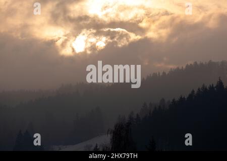 The brightness of the sun forms very different clouds and makes the mountain very mysterious. Stock Photo