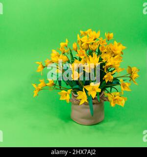 Yellow forest tulips in a ceramic brown vase on a green background. The basis for the postcard. Mother's Day, 8 March. Stock Photo