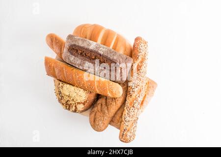 various types of loaves of bread made of wheat, rye, buckwheat flour on a board and white background. top view. a copy of the space Stock Photo