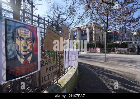 Hamburg, Germany. 10th Mar, 2022. Balloons and flowers in the national colors of Ukraine, as well as posters, hang on a fence opposite the Consulate General of the Russian Federation. Credit: Marcus Brandt/dpa/Alamy Live News Stock Photo