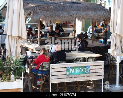 ASHKELON, ISRAEL - MARCH 04, 2022: people relax in an outdoor cafe. Stock Photo