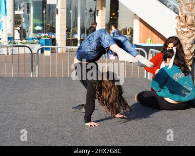 ASHKELON, ISRAEL - MARCH 04, 2022: the girl stands on her hands. Stock Photo