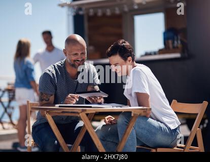 This is what I wanted to show you. Cropped shot of two confident young businesspeople having a meeting together while making use of a digital tablet Stock Photo