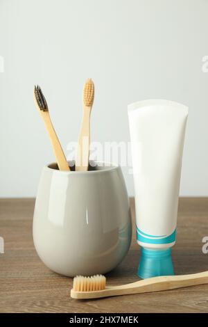 Wooden brush with toothpaste and tube on white background, closeup ...