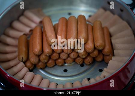 Pigs in blankets. Mini sausages wrapped in smoked bacon in baking dish steamer Stock Photo