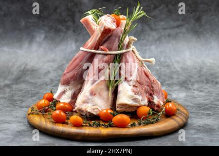 Raw lamb shank on dark background. Lamb shank on wood serving board Stock Photo