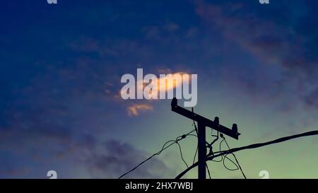 a small cloud is seen above the electric cable strut in the late afternoon atmosphere Stock Photo