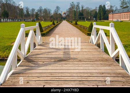 A wooden bridge leading to the walkway of the orangery parterre in the garden of the famous Schwetzingen Palace with the Apollotempel (temple of... Stock Photo