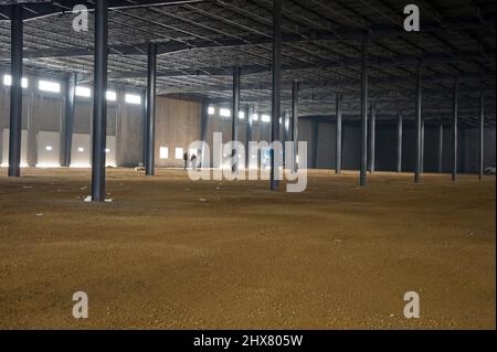 Warehouse under construction with two construction workers in the distance, New Jersey, USA Stock Photo