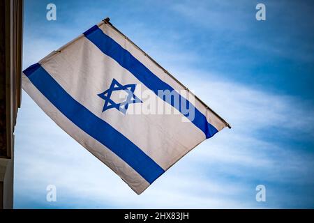 Israeli flag against blue sky and white clouds Stock Photo