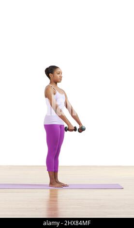 Woman practising Pilates side curls with dumbbells mat exercise, side view Stock Photo