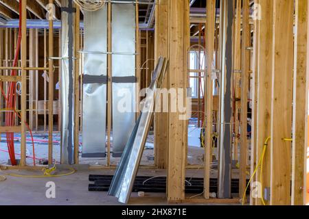 Installation of HVAC tubing vents heating system on the wall, amongst wooden beams Stock Photo