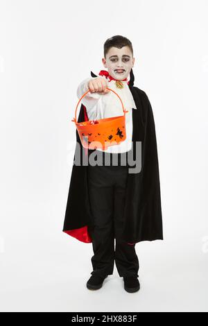 Kid/Model dressed as a Vampire for Halloween with a Trick-or-treat bucket Stock Photo