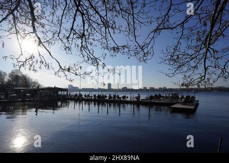 Hamburg, Germany. 10th Mar, 2022. Guests enjoy the afternoon sun on the jetty of the 'Seehaus' on the Außenalster. Credit: Marcus Brandt/dpa/Alamy Live News Stock Photo