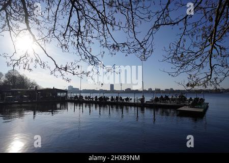 Hamburg, Germany. 10th Mar, 2022. Guests enjoy the afternoon sun on the jetty of the 'Seehaus' on the Außenalster. Credit: Marcus Brandt/dpa/Alamy Live News Stock Photo