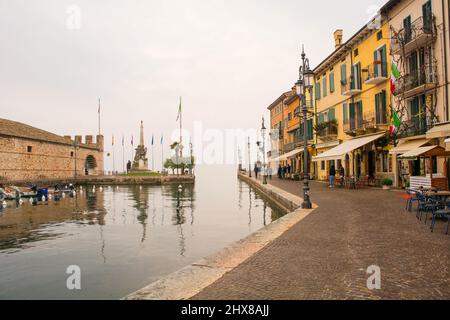 Lazise, Italy - December 27th 2021. Winter at the historic old port waterfront of Lazise on the shore of lake Garda, Verona Province, Veneto, Italy Stock Photo