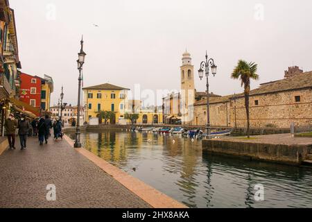 Lazise, Italy - December 27th 2021. Winter at the historic old port waterfront of Lazise on the shore of lake Garda, Verona Province, Veneto, Italy Stock Photo