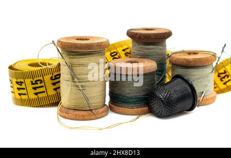 Spools of colored threads, a thimble and a sewing tape measure on a white background. Threads with needles isolate Stock Photo