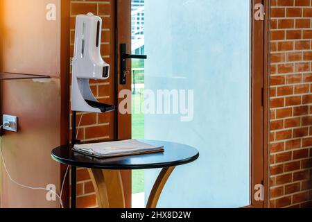 Stand automatic alcohol dispenser spraying with automatic body thermometer check temperature for covid-19 pandemic for safety before entering the coff Stock Photo