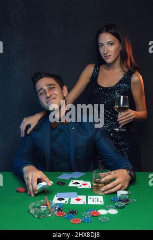 happy-winning-poker-player-with-poker-cards-and-chips-in-casino-2hx8dj8.jpg
