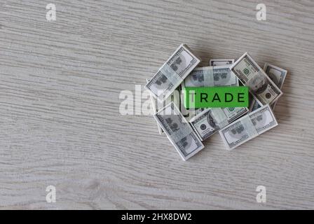 Business concept. Top view image pile of banknotes and wooden cube with text TRADE. Copy space. Stock Photo