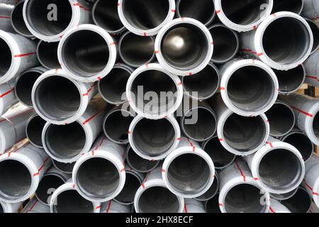 Plastic pipes, tubes or pipelines in cross-section as background stored in a bundle. They are made of durable material and are used in construction. Stock Photo