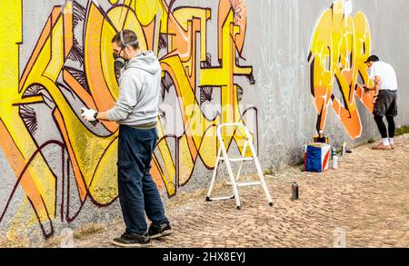 Urban street artists painting colorful graffiti on generic wall - Modern  art concept with guys performing live murales with aerosol color spray -  Focu Stock Photo - Alamy