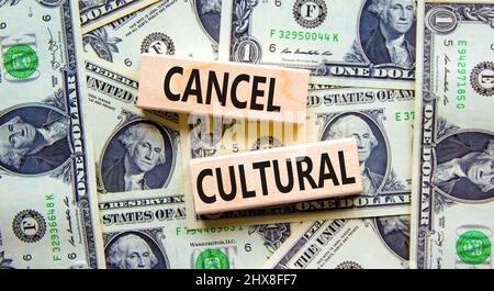 Cancel cultural symbol. Concept words Cancel cultural on wooden blocks on a beautiful background from dollar bills. Business and cancel cultural conce Stock Photo