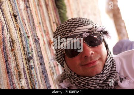 Tourist in arabic kerchief poses in Bedouin tent. Excursion in Egypt Stock Photo